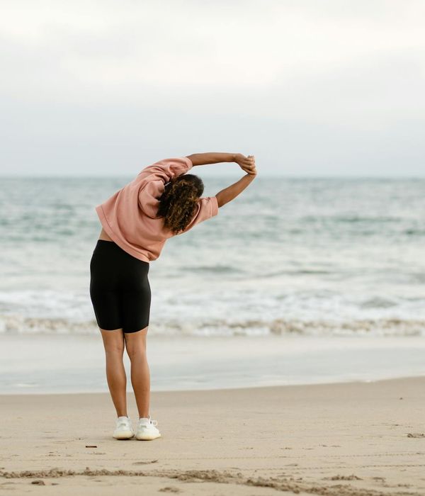 Woman feeling energized and stretching gracefully outdoors.